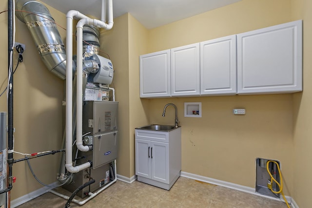 clothes washing area with sink, hookup for a washing machine, and cabinets