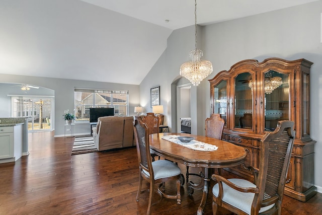 dining space with high vaulted ceiling, dark hardwood / wood-style flooring, and ceiling fan with notable chandelier