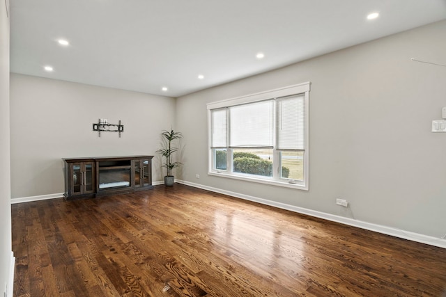 unfurnished living room featuring recessed lighting, dark wood-style flooring, and baseboards