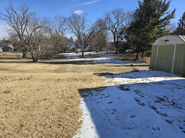 yard layered in snow featuring a storage shed