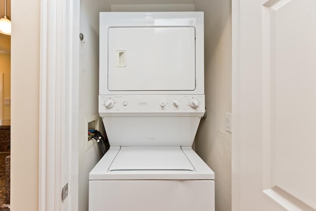 clothes washing area featuring stacked washer / drying machine