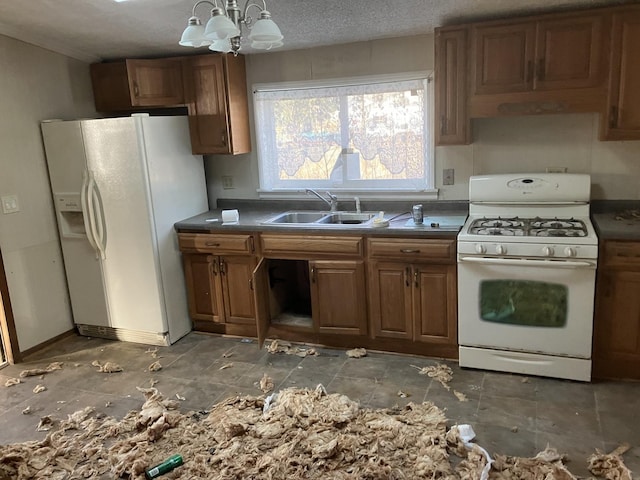 kitchen featuring an inviting chandelier, sink, white appliances, and a textured ceiling