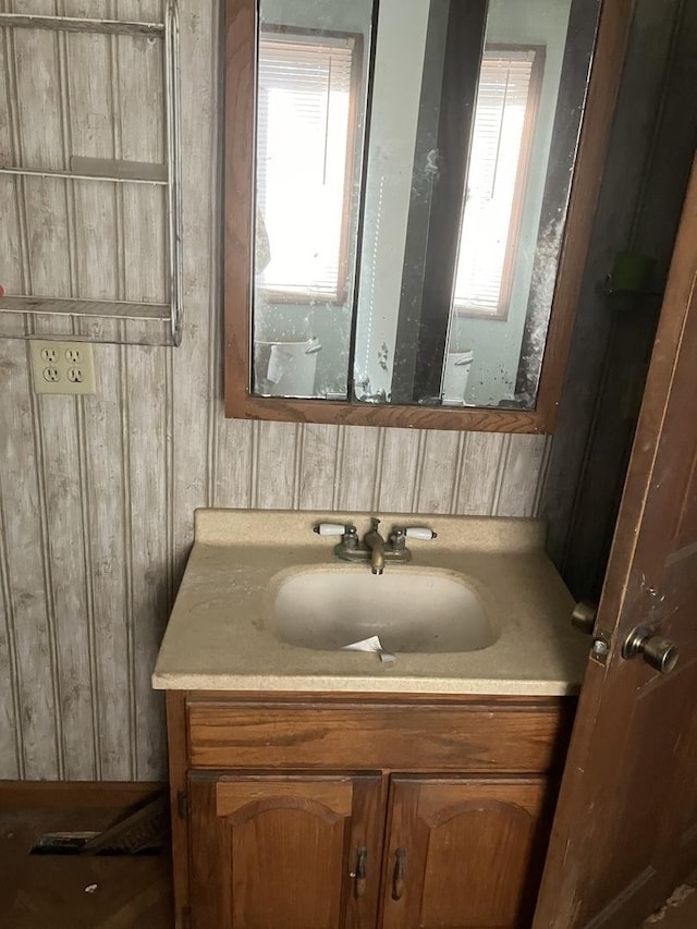 bathroom featuring vanity and wood walls