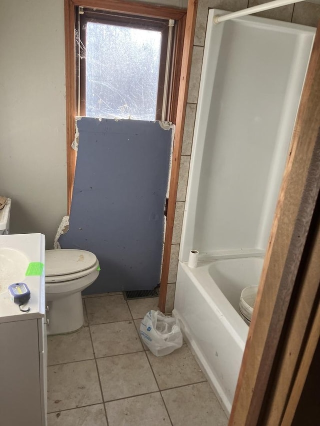 bathroom featuring a tub to relax in, vanity, toilet, and tile patterned flooring