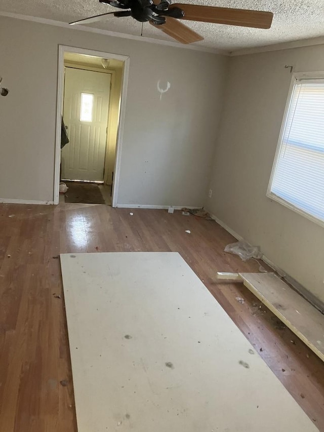 empty room with hardwood / wood-style flooring, ceiling fan, and a textured ceiling