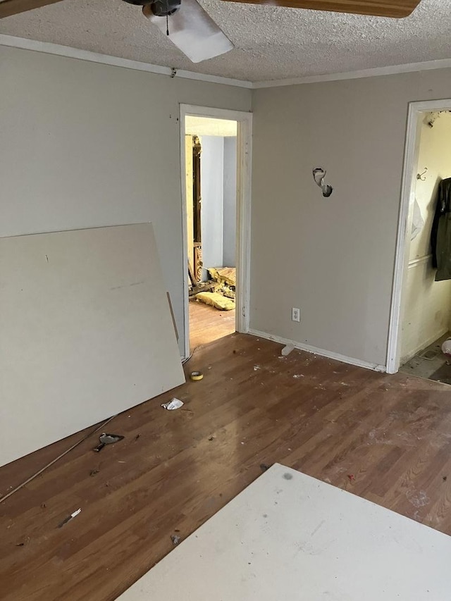 unfurnished room featuring ceiling fan, dark hardwood / wood-style floors, and a textured ceiling