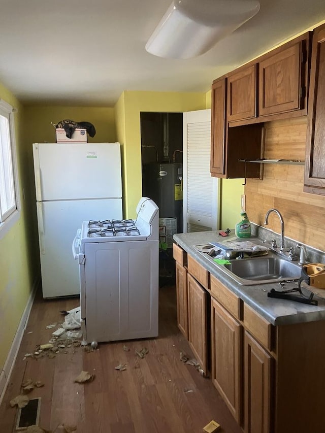 kitchen featuring sink, dark hardwood / wood-style flooring, white appliances, washer / clothes dryer, and water heater