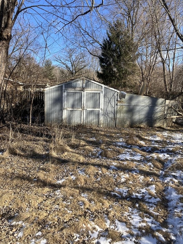 yard layered in snow with a shed