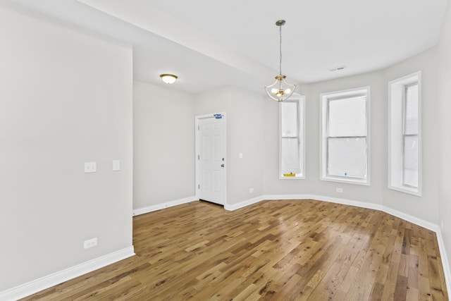 empty room with hardwood / wood-style flooring and a wealth of natural light