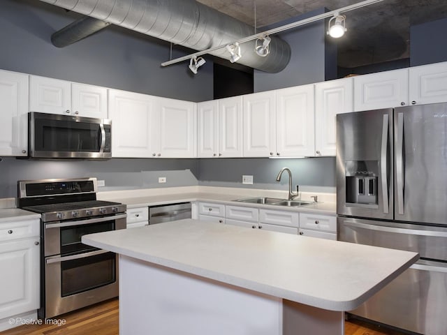 kitchen featuring stainless steel appliances, white cabinetry, and sink