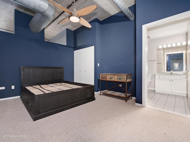 carpeted bedroom featuring ceiling fan, connected bathroom, sink, and a closet