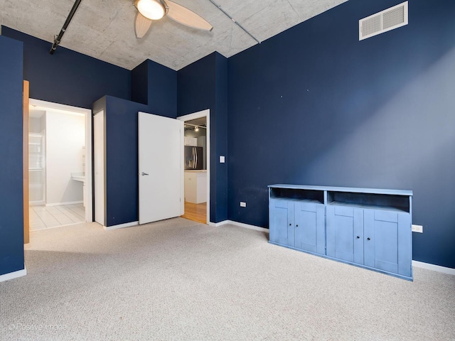 unfurnished bedroom featuring carpet, connected bathroom, stainless steel fridge, and ceiling fan