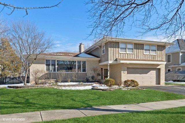 split level home featuring a garage and a front lawn