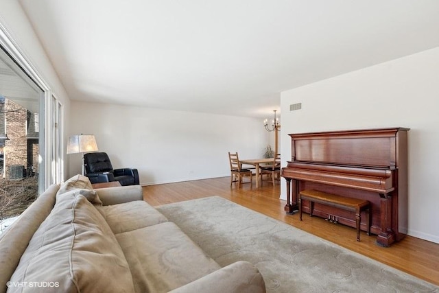 living room with an inviting chandelier and light hardwood / wood-style floors