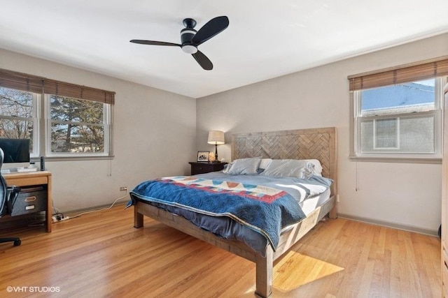 bedroom with multiple windows, light hardwood / wood-style floors, and ceiling fan