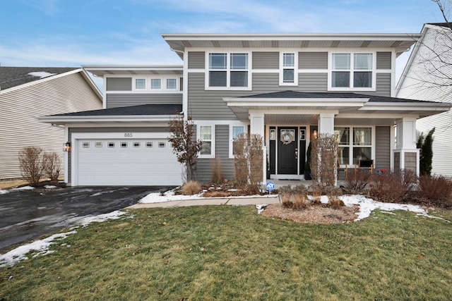 view of front of house featuring a garage, covered porch, and a front lawn