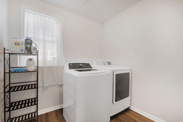 clothes washing area featuring washing machine and dryer and dark hardwood / wood-style flooring