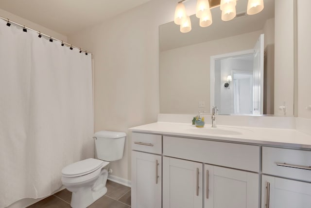 bathroom with tile patterned flooring, vanity, and toilet