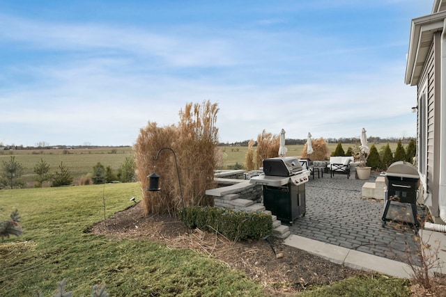 exterior space with a patio, a rural view, and a lawn