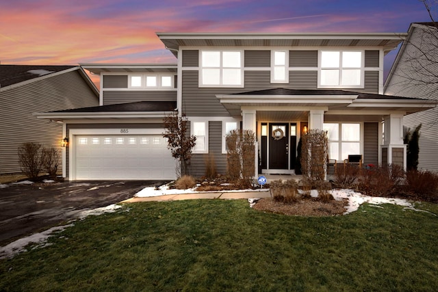 view of front of house featuring a porch, a garage, and a lawn