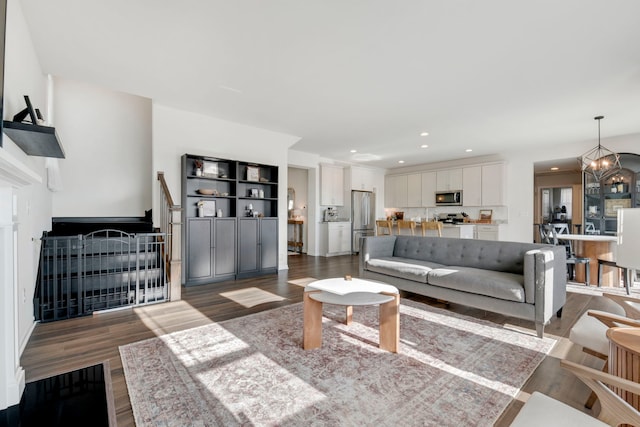 living room with dark wood-type flooring and a notable chandelier