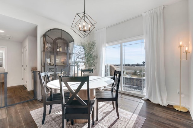 dining room with dark hardwood / wood-style floors and a chandelier