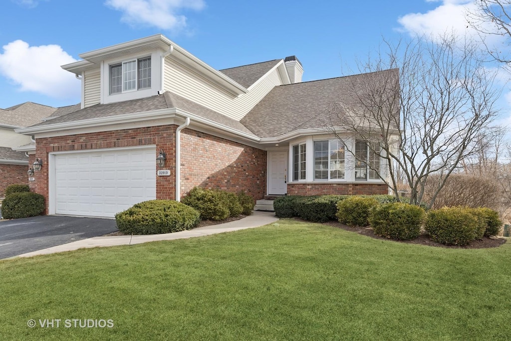 view of front of home with a garage and a front lawn