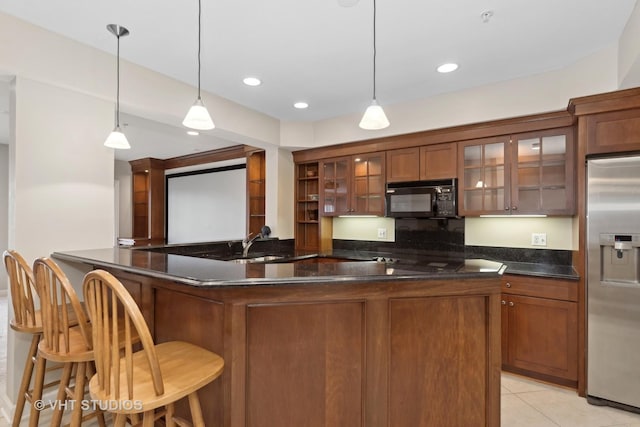 kitchen with a kitchen bar, decorative light fixtures, kitchen peninsula, and stainless steel refrigerator with ice dispenser