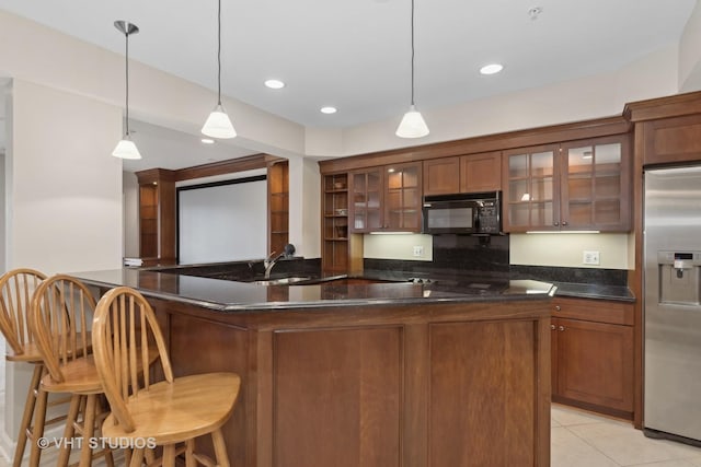 kitchen featuring pendant lighting, a kitchen bar, light tile patterned floors, kitchen peninsula, and stainless steel refrigerator with ice dispenser