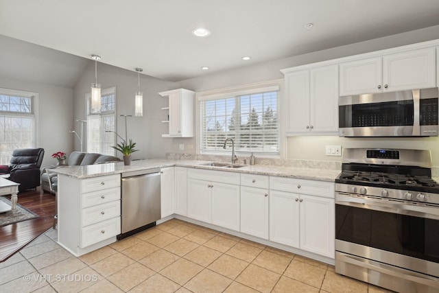 kitchen featuring white cabinetry, appliances with stainless steel finishes, kitchen peninsula, and sink