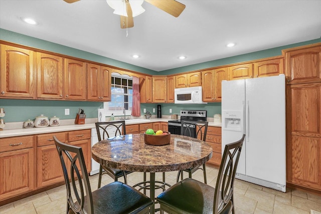 kitchen featuring a sink, white appliances, brown cabinetry, and ceiling fan