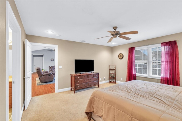 bedroom with light carpet, ceiling fan, and baseboards