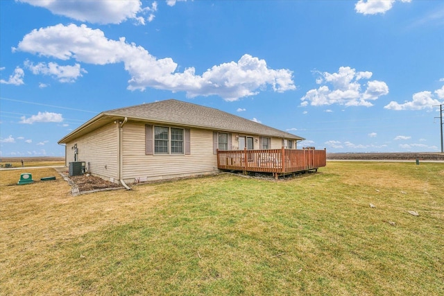 back of property with a deck, a lawn, and central AC