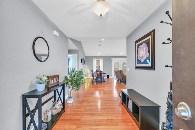 hall with light wood-style floors and baseboards