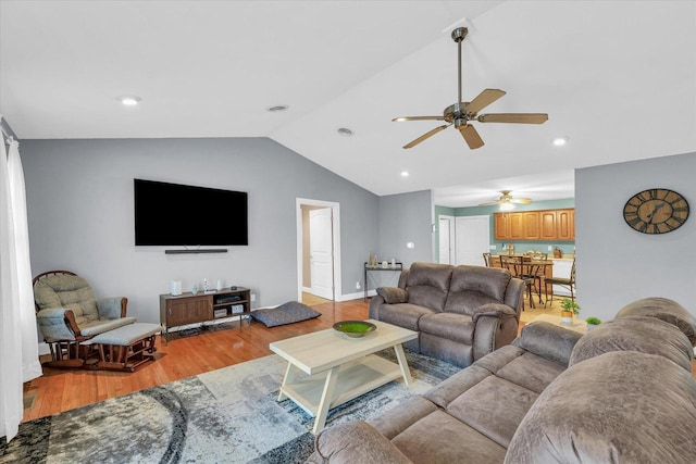 living room with vaulted ceiling, light wood-style floors, baseboards, and ceiling fan