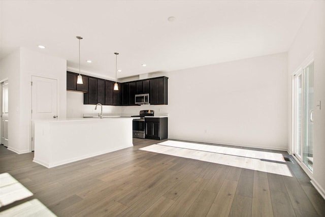 kitchen featuring sink, a center island with sink, hanging light fixtures, light hardwood / wood-style flooring, and appliances with stainless steel finishes