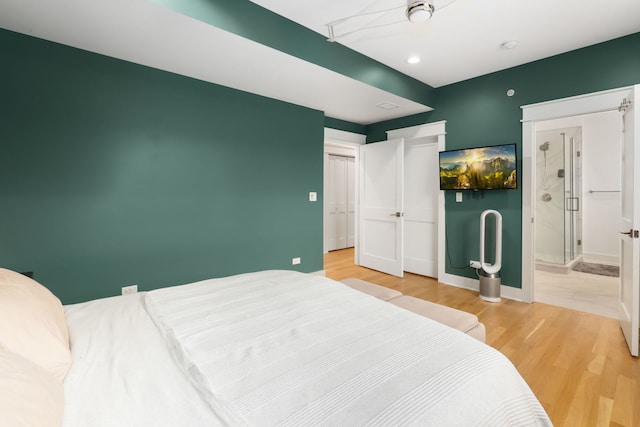 bedroom featuring ensuite bath and light hardwood / wood-style flooring