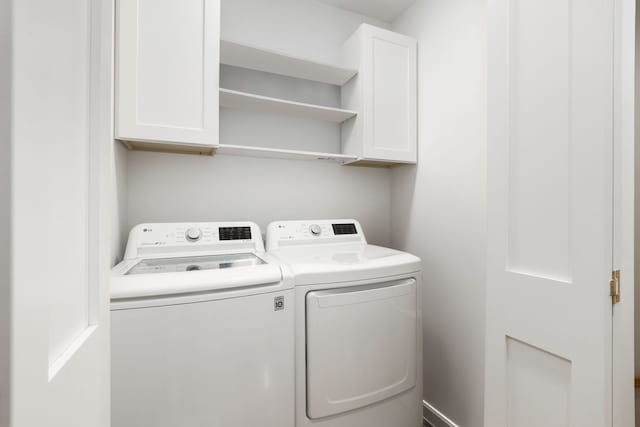 washroom featuring washer and dryer and cabinets