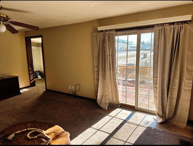 unfurnished living room with ceiling fan, carpet floors, and a textured ceiling