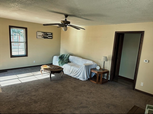 living room with ceiling fan, carpet flooring, and a textured ceiling