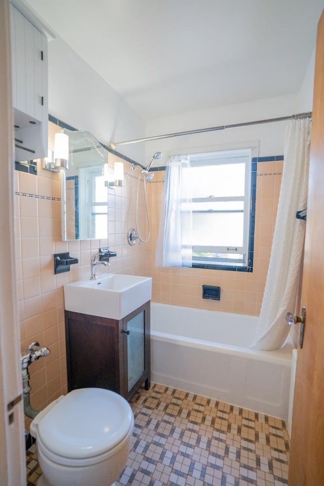 full bathroom with shower / tub combo, tile patterned flooring, tile walls, vanity, and toilet