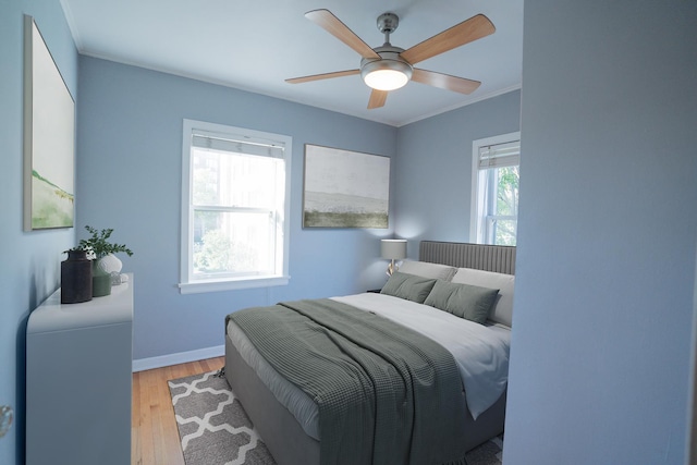 bedroom with crown molding, ceiling fan, and light wood-type flooring