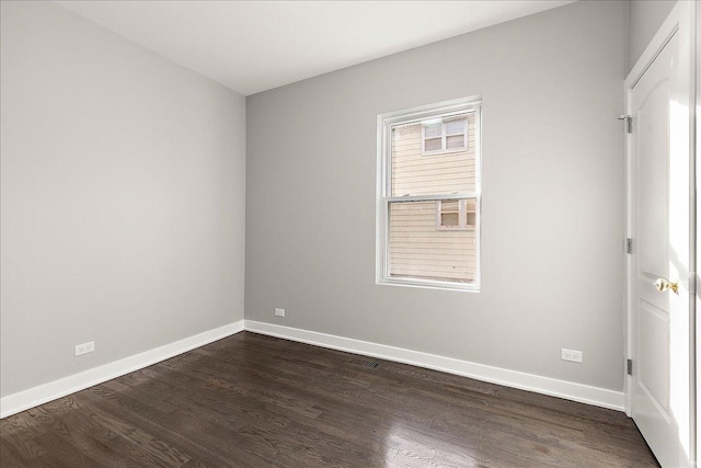 empty room with dark hardwood / wood-style flooring