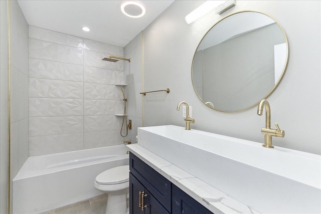 full bathroom featuring tiled shower / bath, vanity, tile patterned floors, and toilet