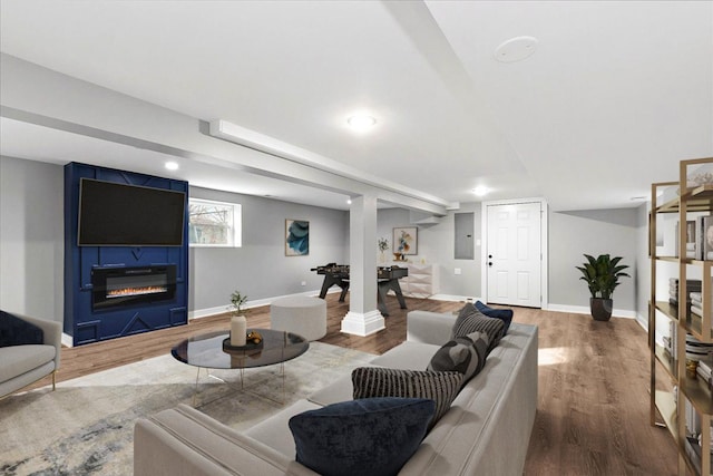 living room featuring hardwood / wood-style floors, electric panel, and a large fireplace