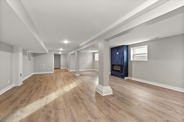 basement with plenty of natural light and light hardwood / wood-style floors