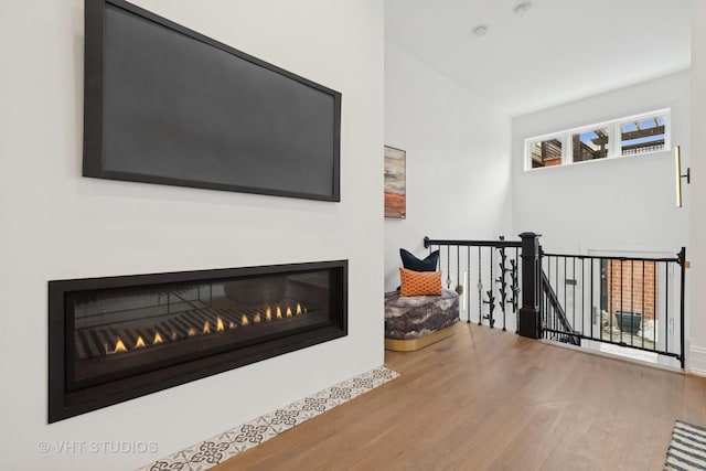 interior space featuring wood finished floors and a glass covered fireplace