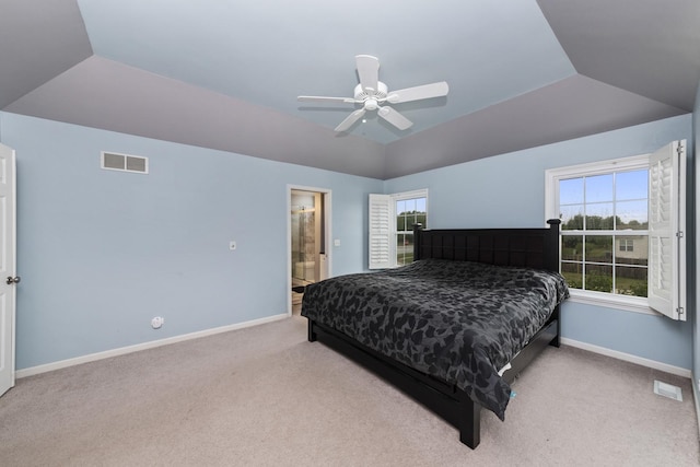 bedroom with ceiling fan, connected bathroom, vaulted ceiling, and light carpet