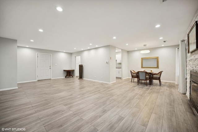 living room featuring a fireplace and light wood-type flooring