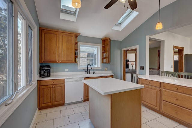 kitchen with pendant lighting, dishwasher, sink, a center island, and light tile patterned floors